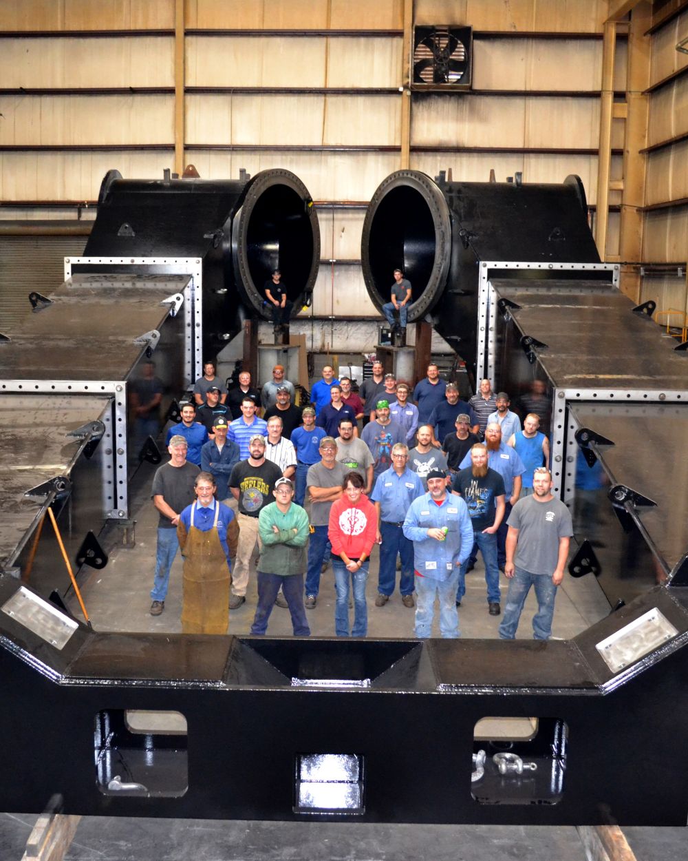 Brilex employees gathered for a team photo inside a large fabricated steel component