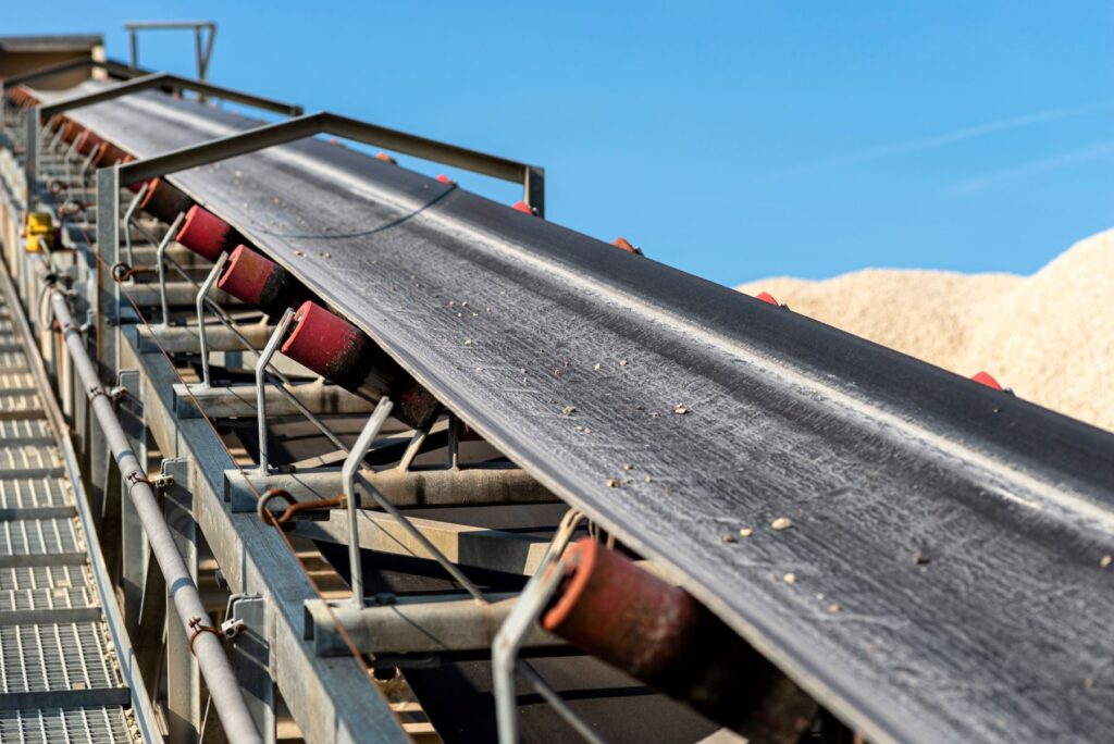 Mining conveyor belt carrying material against a blue sky, an industry served by Brilex